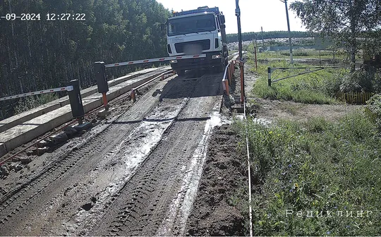 Кадр камеры на весовой: мусоровоз на выезде у шлагбаума, номер скрыт