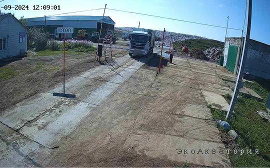 Кадр камеры на весовой: мусоровоз на дальнем краю весов, номер скрыт